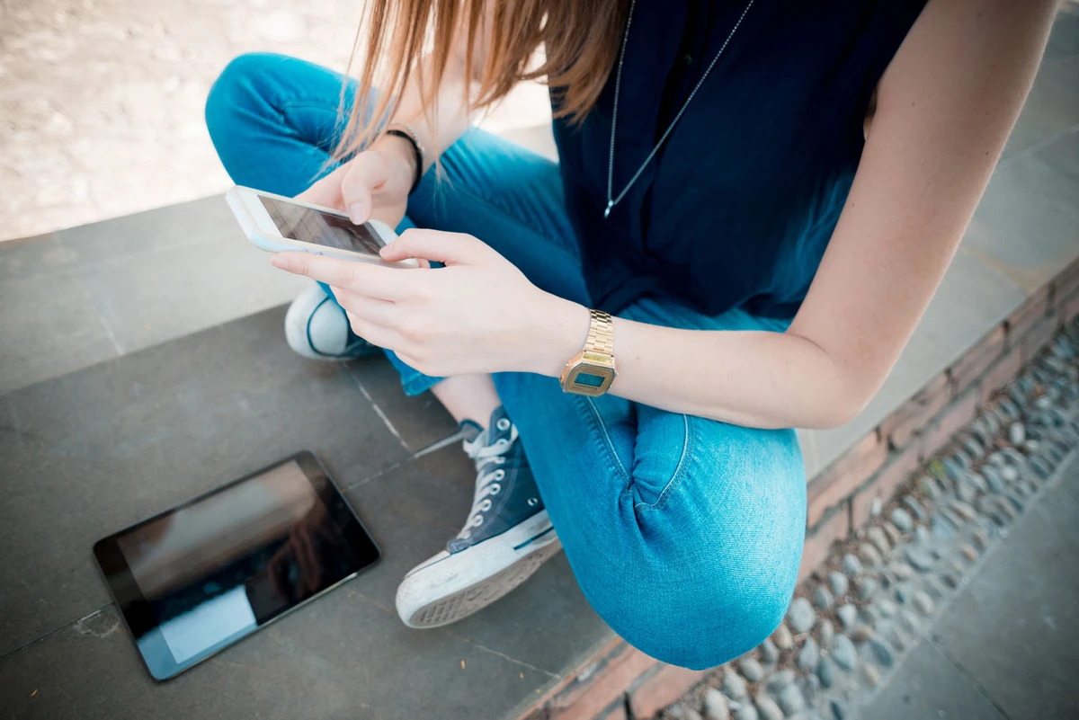 Et barn sidder med sin telefon