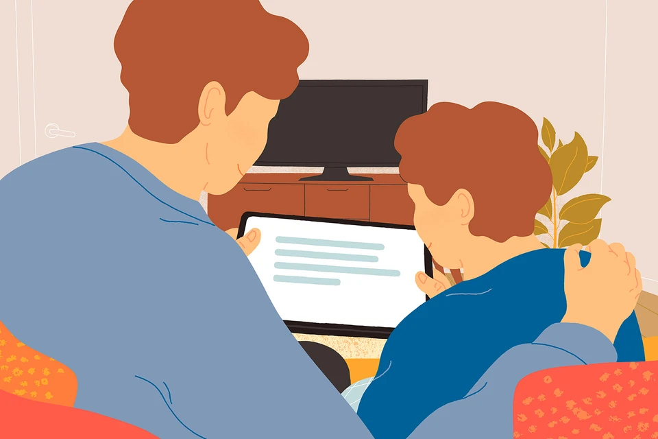 En voksen og et barn kigger på en tablet.