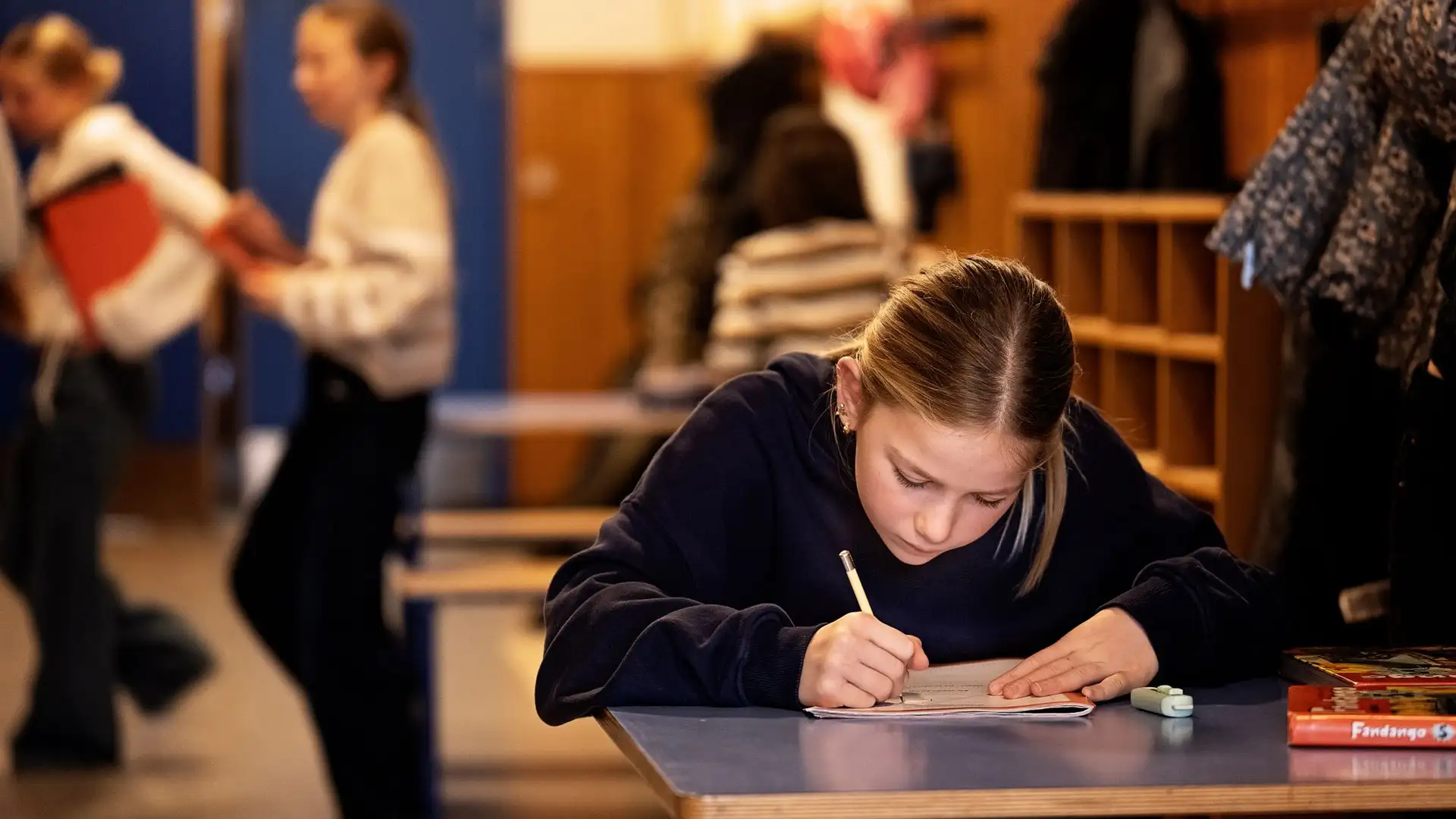 En elev sidder i skolen og skriver.
