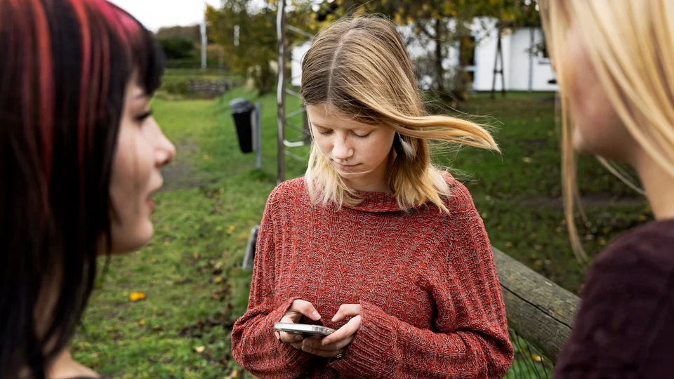 En pige kigger på sin smartphone.