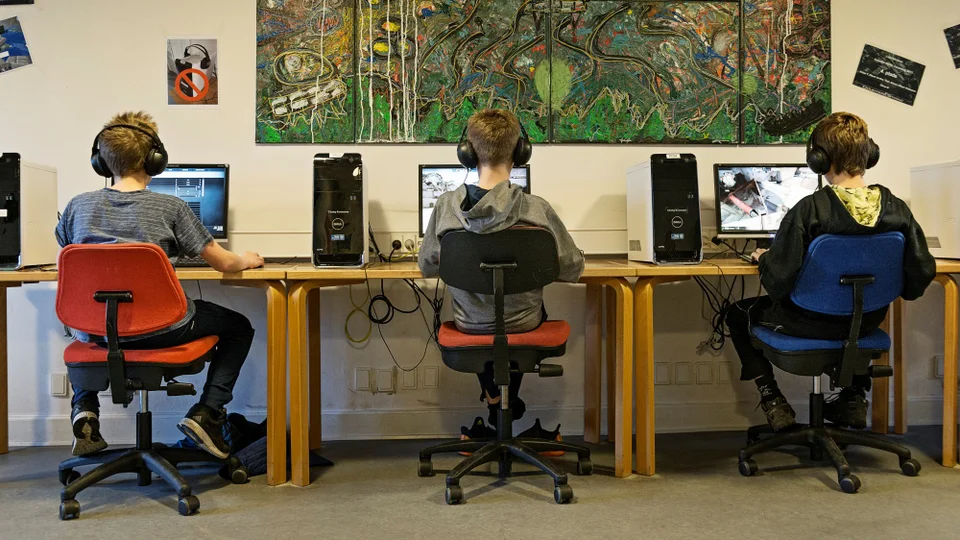Tre børn spiller computer.